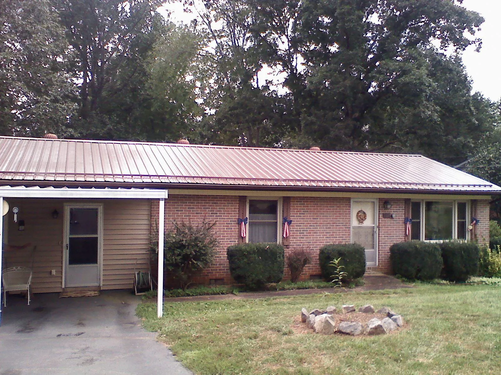 Bronze metal roof and carport on a brick ranch home — Roof Repair work by our crew in Port Arthur