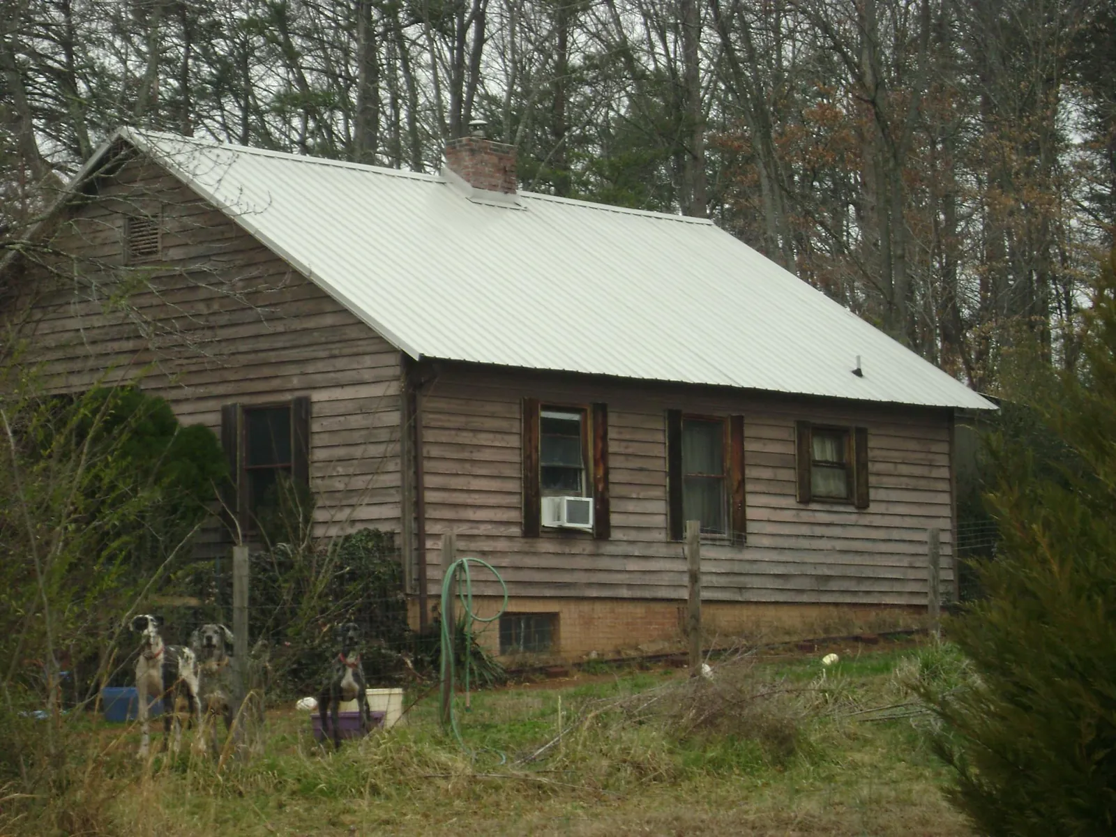 White metal roof on an old wood sided farmhouse, from a Metal Roof Installation job in Port Arthur